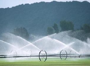Irrigation system in field with tall hills in the background.