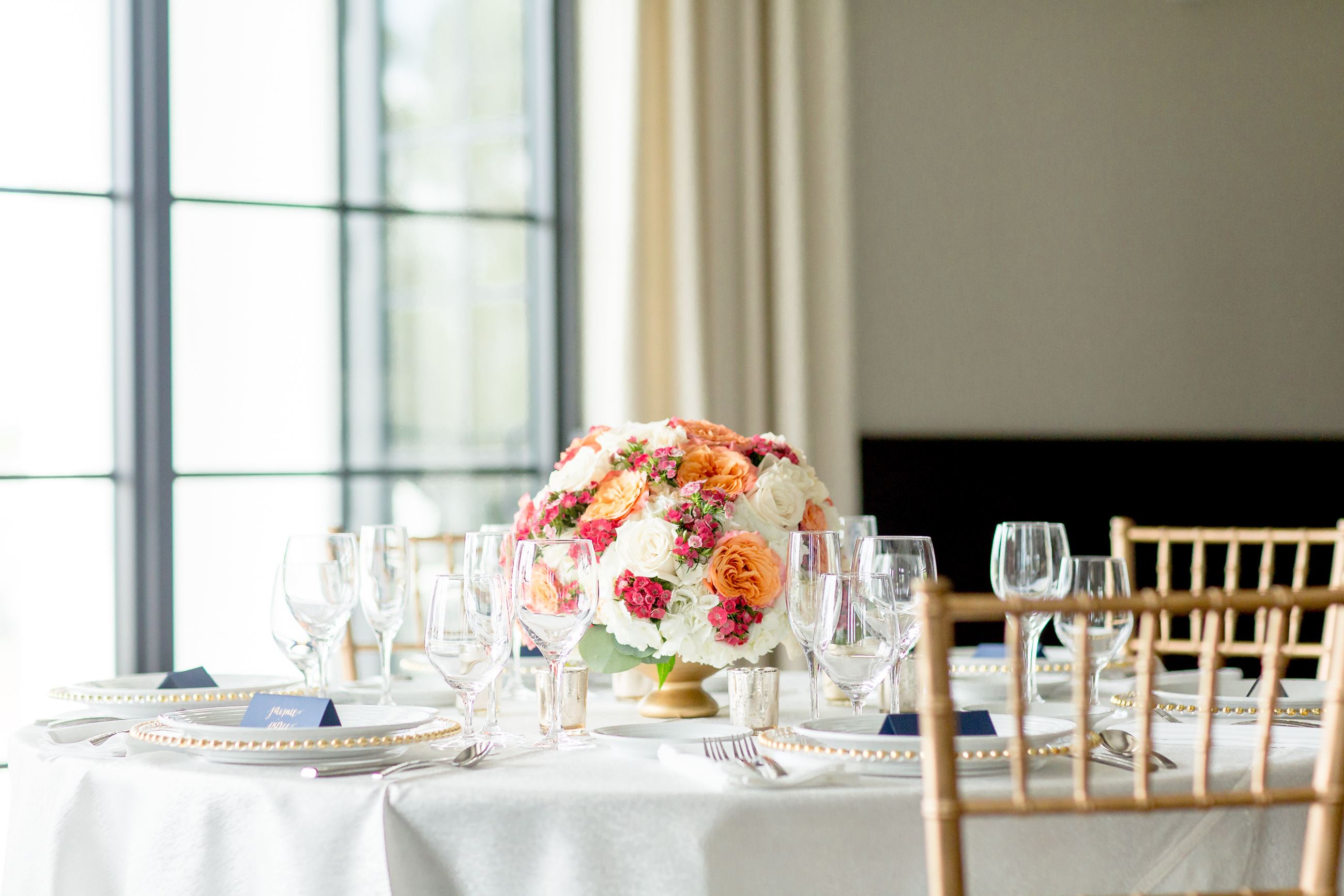 Flower centerpiece on table and gold chairs